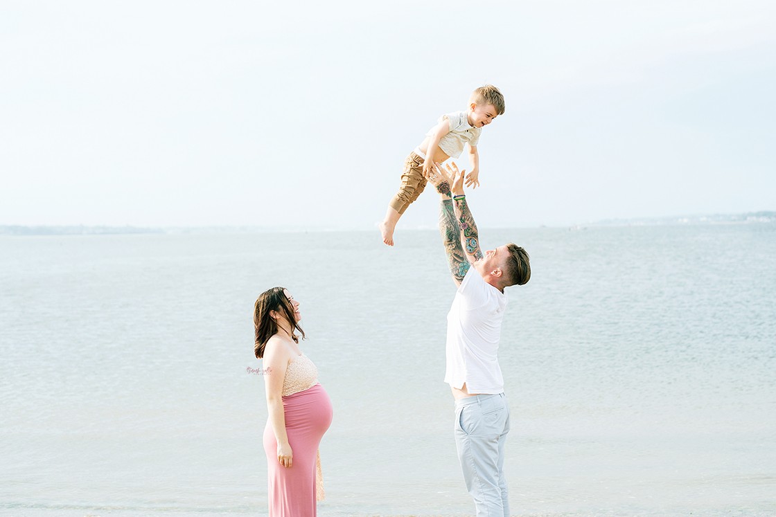 In Studio + Outdoor Maternity Photography and Photo Session Warwick, RI, Conimicut Village, Conimicut Point - family tossing son in the air near water