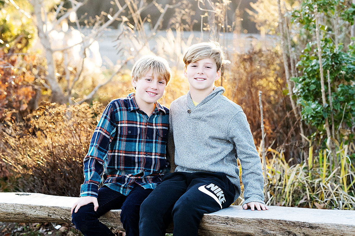 Fall Family mini Photo Session & Photography at "The Farmer's Daughter" in South Kingstown, RI - boys sitting on bench embracing