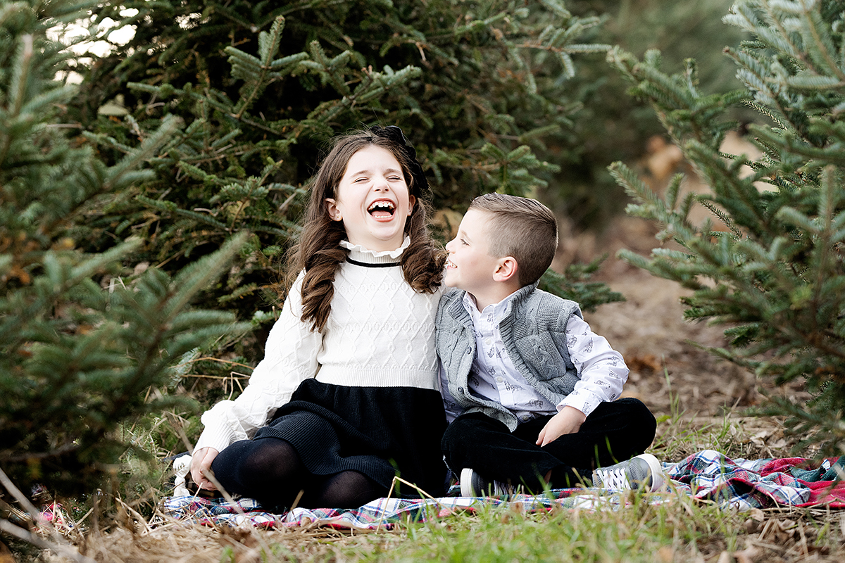 Family Photography and Photo mini Sessions at The Farmer's Daughter Tree Farm in South Kingstown, RI - brother and sister laughing on ground